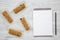 Granola bars on baking sheet and blank notepad over white wooden background, top view.