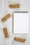 Granola bars on baking sheet and notepad over white wooden surface, top view.