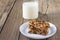 Granola bars with nuts and dried fruits, glass of milk