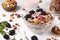 Granola crispy honey muesli with natural yogurt, berries, chocolate and nuts in a bowl against a light background, healthy food,
