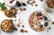 Granola crispy honey muesli with natural yogurt, berries, chocolate and nuts in a bowl against a light background, view from above