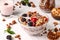 Granola crispy honey muesli with natural yogurt, fresh berries, chocolate and nuts in a bowl against a light background, healthy