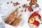 Granola in a glass bottle with hazelnuts on a light background. Ripe apples in a metal basket. The concept of a healthy Breakfast