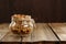 Granola in jar with packing-twine on wooden background with space