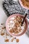 Granola muesli with fresh milk and pieces of chocolate in a pink plate
