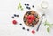 Granola muesli, milk and ripe blueberries and raspberries, healthy breakfast concept, wooden background, top view