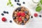 Granola muesli, milk and ripe blueberries and raspberries, healthy breakfast concept, wooden background, top view