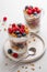 Granola with yogurt in glass served with fresh raspberry, blueberry and honey. Homemade oatmeal muesli. Vegetarian breakfast.