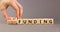 Grant funding symbol. Concept words Grant funding on beautiful wooden blocks. Beautiful grey table grey background. Businessman