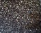 Granular texture of concrete with gravel particles, small stones, black, gray and white grains. Close up, top view. The texture of