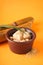 Granulated brown sugar, sugarcane and green leaf on a orange background, closeup. Vertically