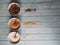 Granulated sugar, demerara and brown sugar in crockery bowls on an old wooden table.