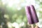 Grape flavored popsicle in hand