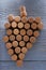 Grape made of wine bottle corks on grey wooden table, top view