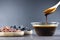 Grape molasses in glass bowl , in wooden spoon and dried black and green grapes