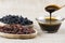 Grape molasses in glass bowl , in wooden spoon and dried black and green grapes