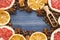 Grapefruit and lemon slices, coffee beans, cinnamon, star anise and wooden spoon on blue wooden background