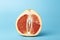 Grapefruit minimal erotic concept. Half a juicy grapefruit close up on a colored background