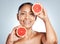 Grapefruit, portrait and vitamin c skincare of happy woman on studio background. Beauty model, face and citrus fruits