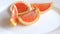 Grapefruit Slices On A White Plate