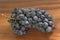 Grapes. A bunch of dark, black grapes lies on a wooden board close-up