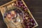 Grapes cut in half with bones on the background of a cluster of blue grapes in a wooden box on a dark table. Place and background