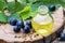 Grapes essential oil in a glass bottle and dice on old wooden boards. Blue grape. Spa, eco products concept