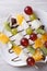 Grapes, kiwi, pear and orange on skewers vertical top view