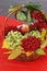 Grapes, viburnum, apples in a wicker basket close-up. seasonal fruits