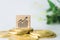 Graph rising up growht exponencial sign on wooden cube with objects such as gold coin, calculator and mini home model behide white
