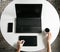 Graphic designer working at a white table using laptop and graphics tablet. Famale hands.