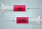 A graphic illustration of two syringes with the words GIVE BLOOD to encourage people to donate their blood and plasma to help