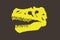 Graphical yellow silhouette of skull of dinosaur raptor on brown background, vector color illustration