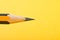 Graphite wooden pencil on yellow background