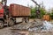 A grapple truck loads scrap industrial metal for recycling.