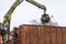 A grapple truck loads scrap industrial metal for recycling