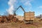 A grapple truck loads scrap industrial metal for recycling.