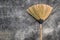 A grass broom lay against the old cement wall.