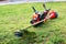 Grass cutter / Brush cutter, safety helmet and other equipment lay on the lawn