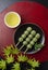 Grass dumplings and green tea placed on a red Japanese tray