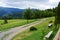 Grass field with field road and wooden benches near Dolni Lomna in Czech Republic during cloudy late summer a