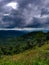 Grass green tropical trees roads street curves valley rain forest jungle dark sky sun light shine pai chiang clouds view