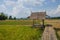 Grass pavilion with bamboo bridge in harvesting rice filed