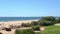 Grassy field near a pleasant looking beach and glistering ocean water in Vale do Lobo, Portugal.