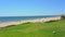 Grassy field near a pleasant looking beach and glistering ocean water in Vale do Lobo, Portugal.