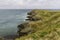 Grassy headland or peninsula with coastguard lookout in distance