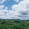 Grassy hills and with few trees and cumulus clouds on blue sky at Nasugbu, Batangas, Philippines