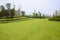 Grassy lawn and garden on hillside in cloudy summer