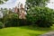 Grassy lawn before hedged European-style houses in sunny autumn