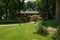 Grassy lawn before wayside building in trees on sunny summer day